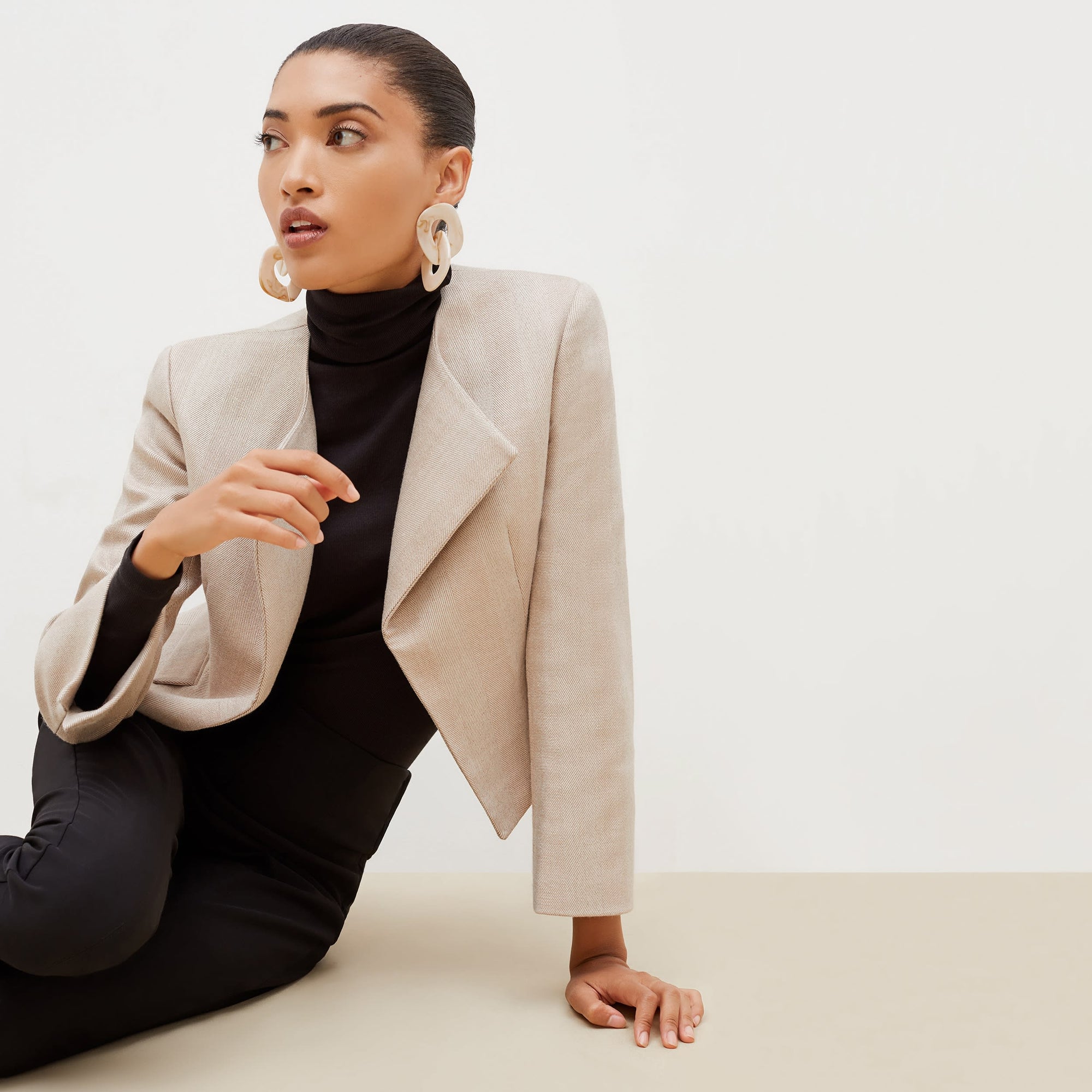 Detail image of a woman standing wearing the axam top in black | Exclude