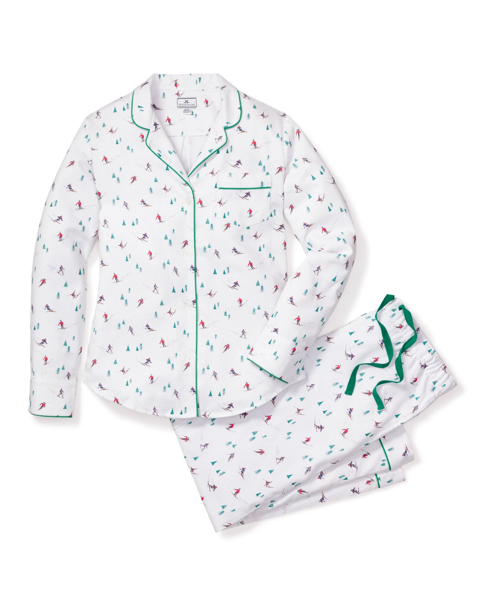 Petite Plumes Womens Flannel Pajama Set in Apres Ski features white pajamas adorned with holiday-themed red and green skiers. Made from brushed cotton flannel, it includes a long-sleeve button-up top with a chest pocket and matching pants with an elastic waistband, highlighted by green piping edges.