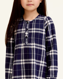 The Girl's Brushed Twill Beatrice Nightgown in Oxford Tartan features a navy, white, and gray plaid pattern, long sleeves, a round neckline, front buttons, and pleats near the chest.