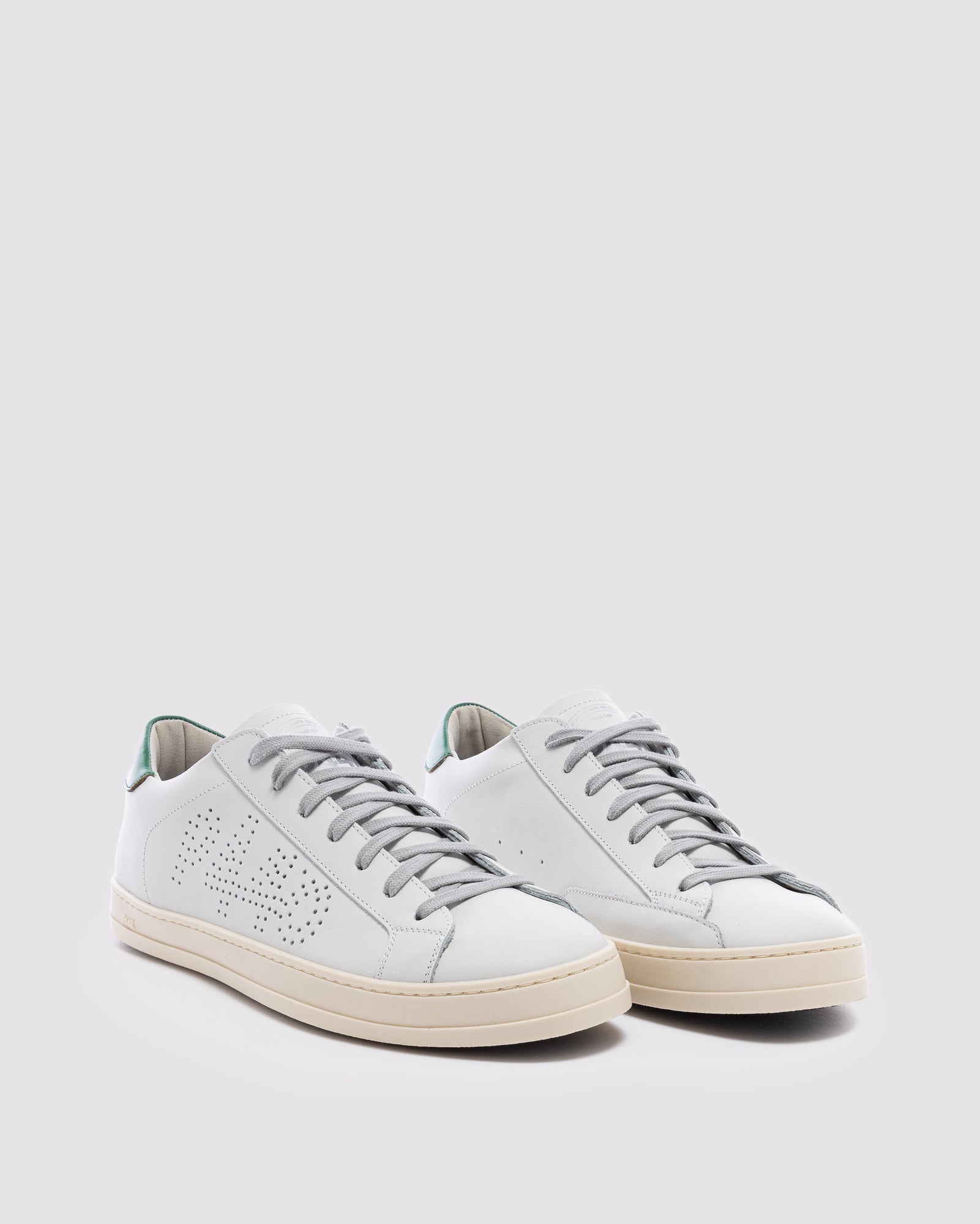 Side angle of white and  green sneakers
