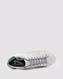Side angle of white and  green sneakers