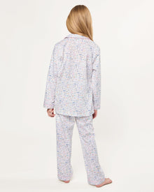 The Kid's Twill Pajama Set in Baking Spirits Bright features white long-sleeve button-up top and long pants with a colorful print of various small household and travel items.