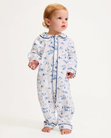 The Baby's Twill Cambridge Romper in Chalet Toile is a white long-sleeve, full-length onesie with blue alpine scene prints and blue piping on the collar, cuffs, and front placket.
