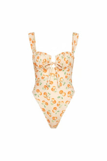 Cream one-piece swimsuit with orange cherry and green leaf print, sweetheart neckline, and bow tie detail.
