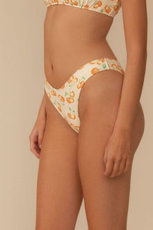 Cream bikini bottom with orange cherry print and zig-zag stitch detailing on waistband and leg openings.