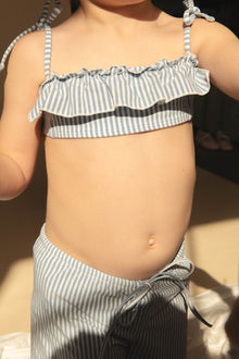 Child wearing blue and white striped swim bottoms with drawstring waist.