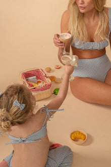 Blue and white striped drawstring shorts with matching bikini top on woman and child.