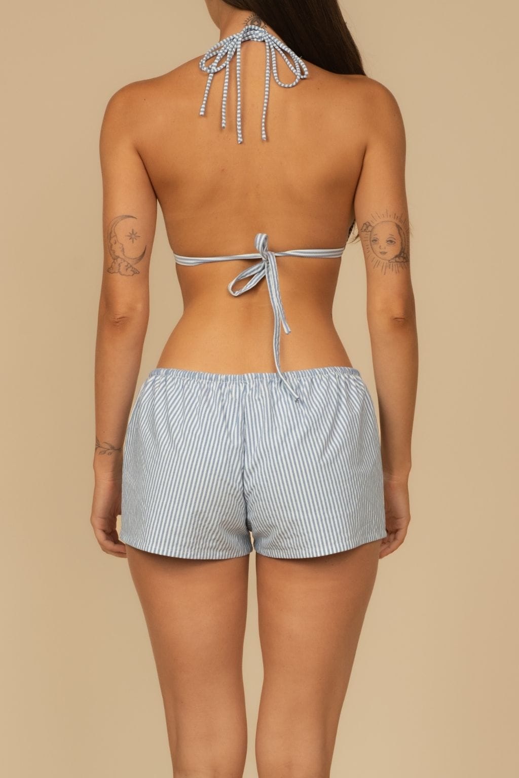 Blue and white striped low-rise shorts with drawstring waist, shown from back view.