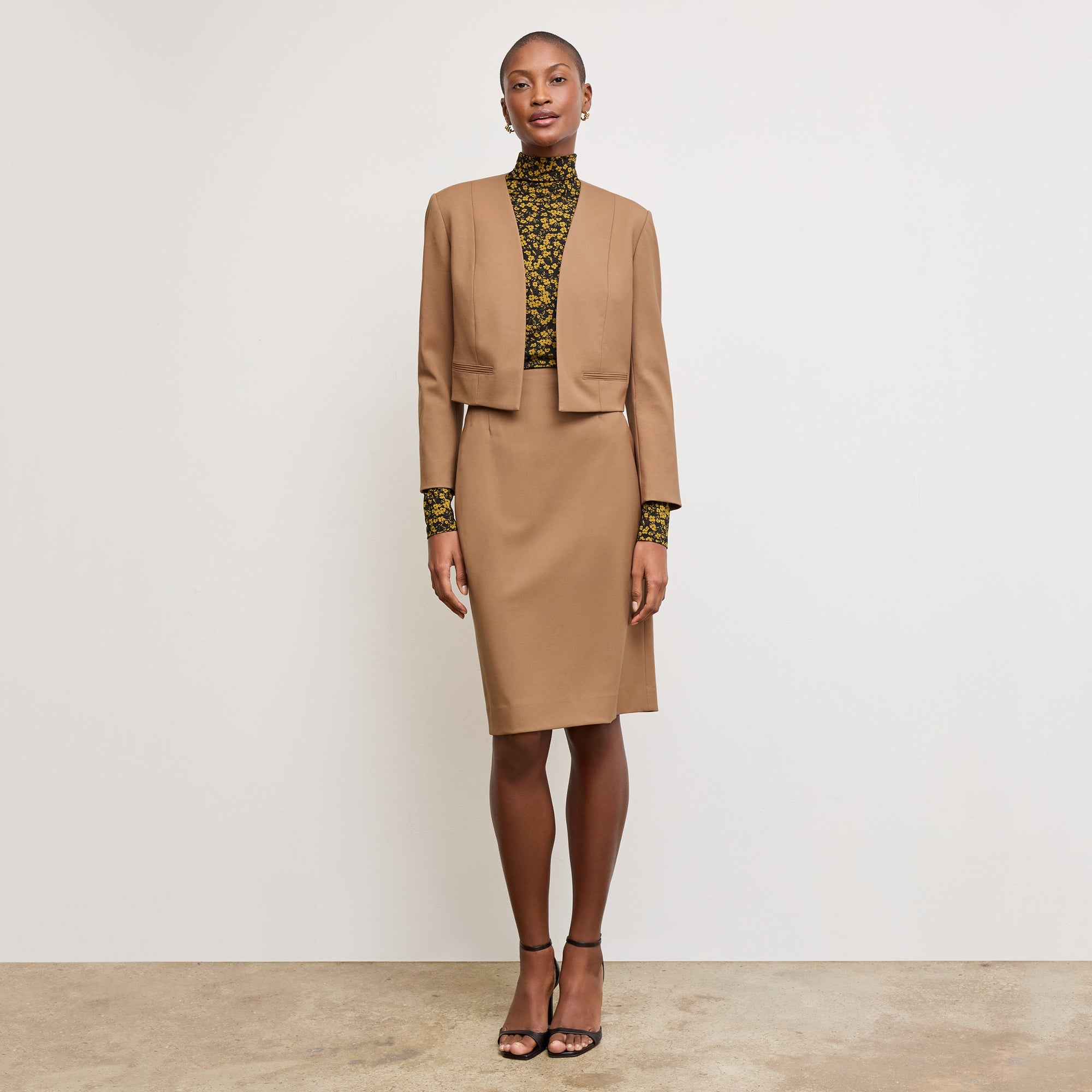 Front image of a woman standing wearing the Neale jacket in camel | Exclude