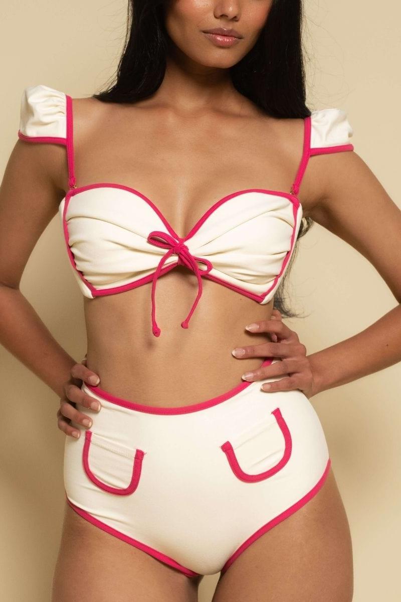 Cream bikini top with hot pink binding, bow tie center, and ruffled off-shoulder straps.