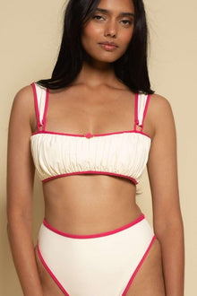 Cream bikini top with raspberry pink binding on straps, neckline, and underband with gathered fabric detail.