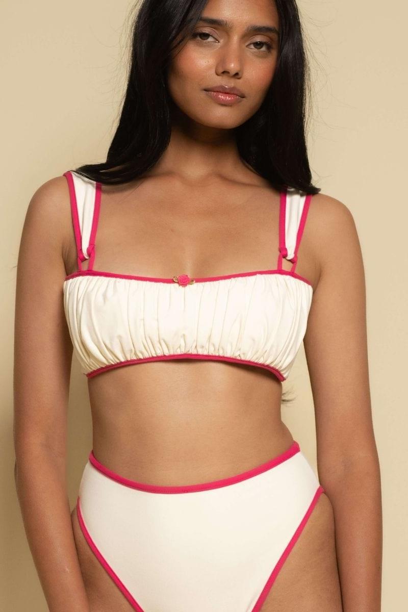 Cream bikini top with raspberry pink binding on straps, neckline, and underband with gathered fabric detail.