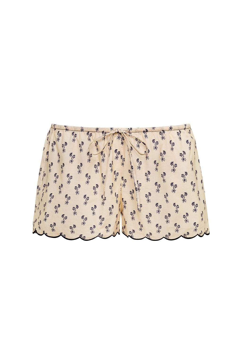 Cream shorts with small purple floral print and scalloped trim at legs, featuring drawstring waist.