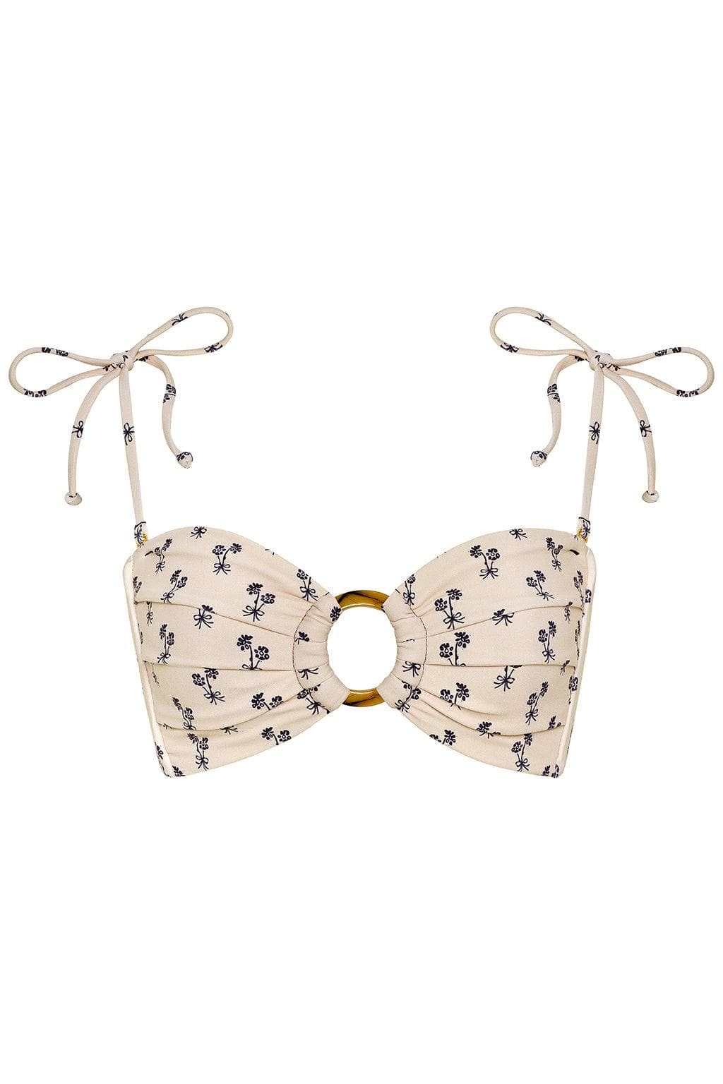 Cream bandeau bikini top with small dark floral print, gold ring detail at center, and beige tie straps with decorative beads