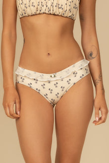 Cream bikini bottom with small black floral print and ruffle waistband detail.