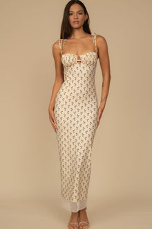 Cream slip dress with small dark floral print, sweetheart neckline, tie shoulder straps, and ankle-length silhouette.