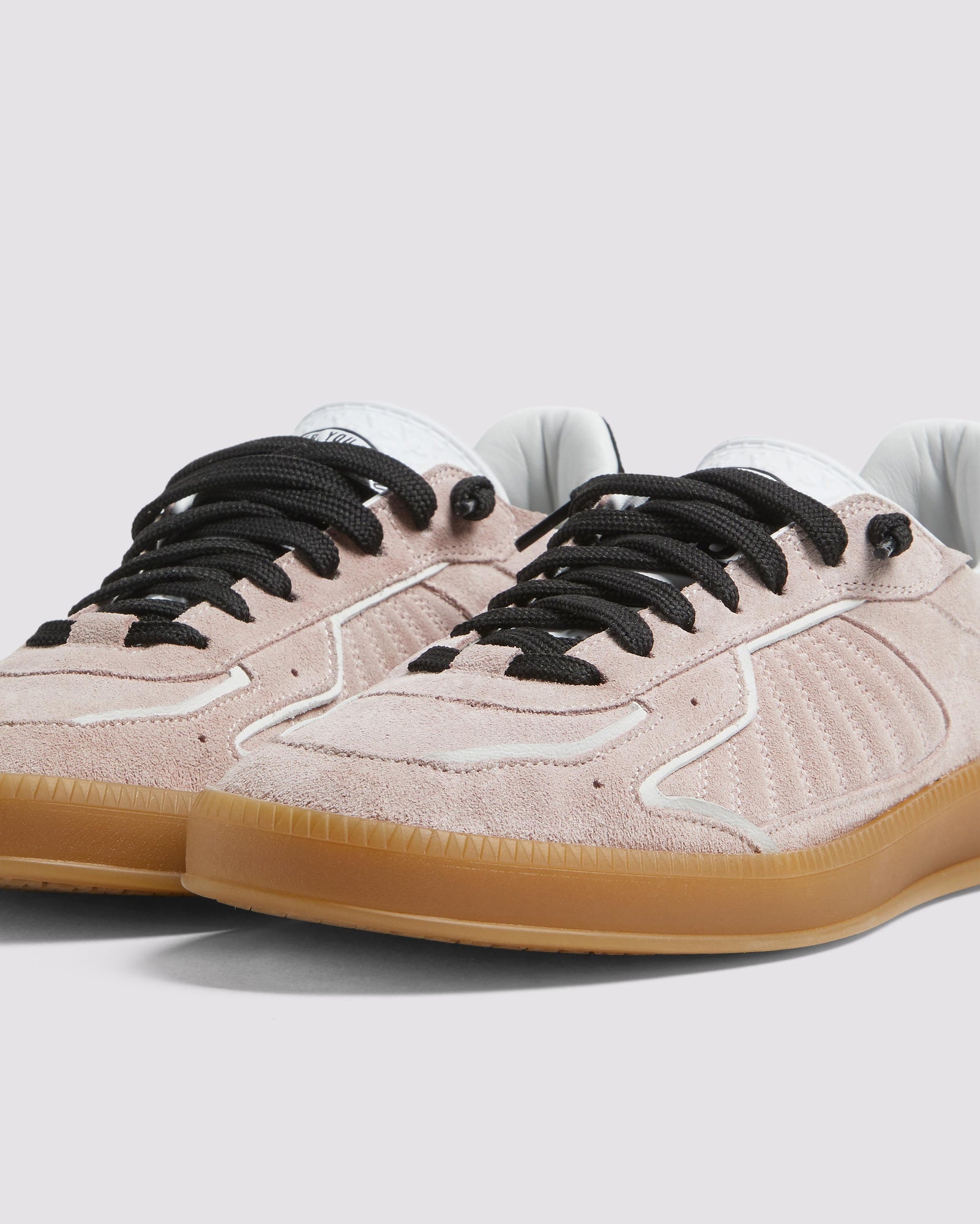 Side angle of light pink and black sneakers