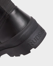 Close-up of the heel of RITA - L222502 Black women's winter boot. Features a textured rubber sole and weather-treated leather with 
