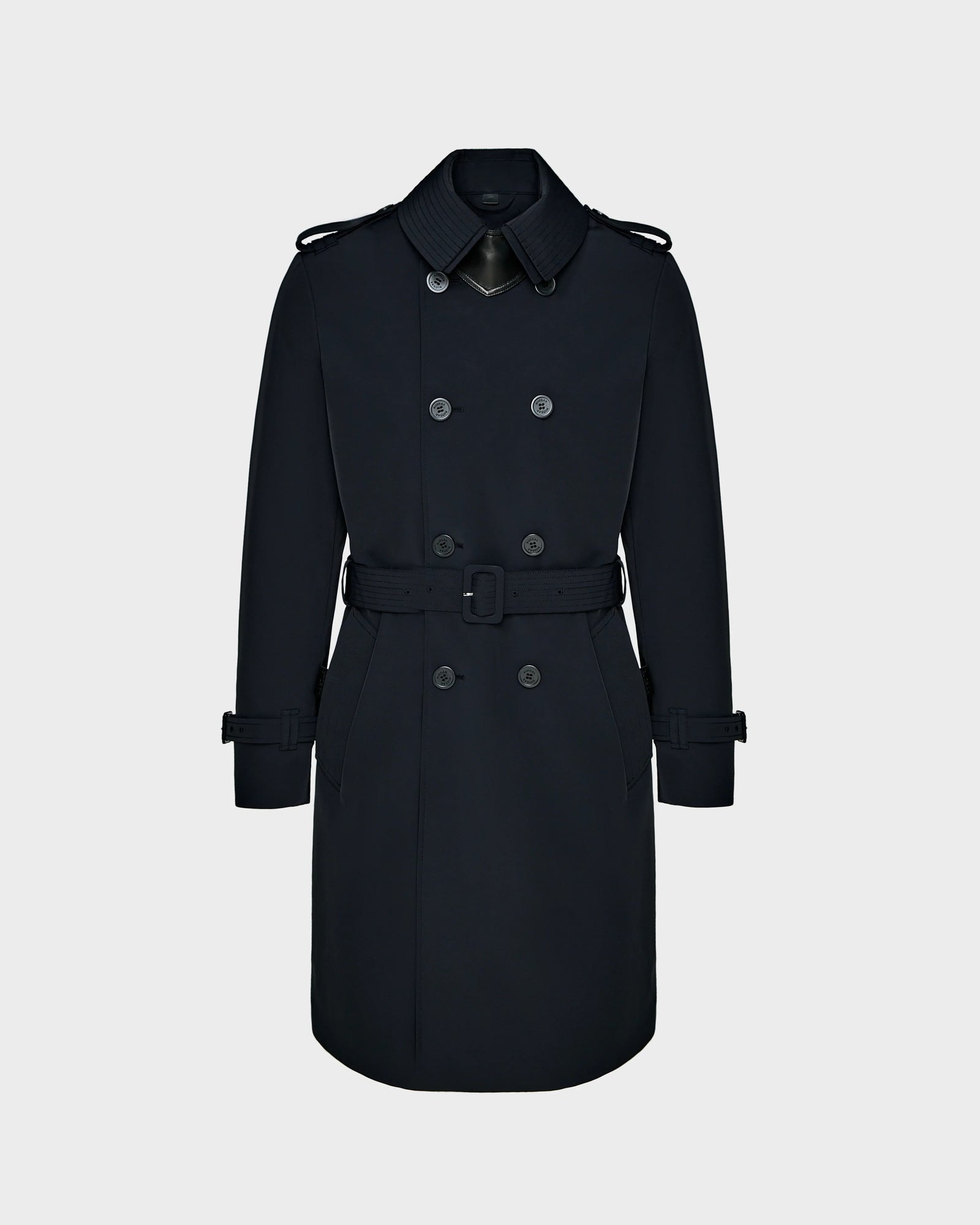 The Rudsak TIMOTHY - 6124589 Black is a mens knee-length trench coat with a double-breasted front, waist belt, shoulder epaulets, and buckle strap cuffs, shown against a plain light gray background.