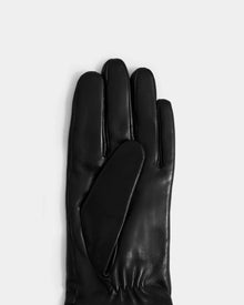 The Rudsak AUGUSTA - L425546 Black women’s glove, crafted from black lamb leather, is displayed on a plain white background with fingers facing upward—a true essential for cold weather.