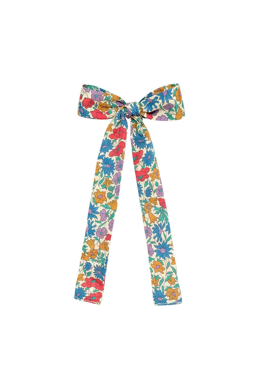 Multicolored floral hair ribbon bow with red, blue, yellow, and purple flowers on cream background.