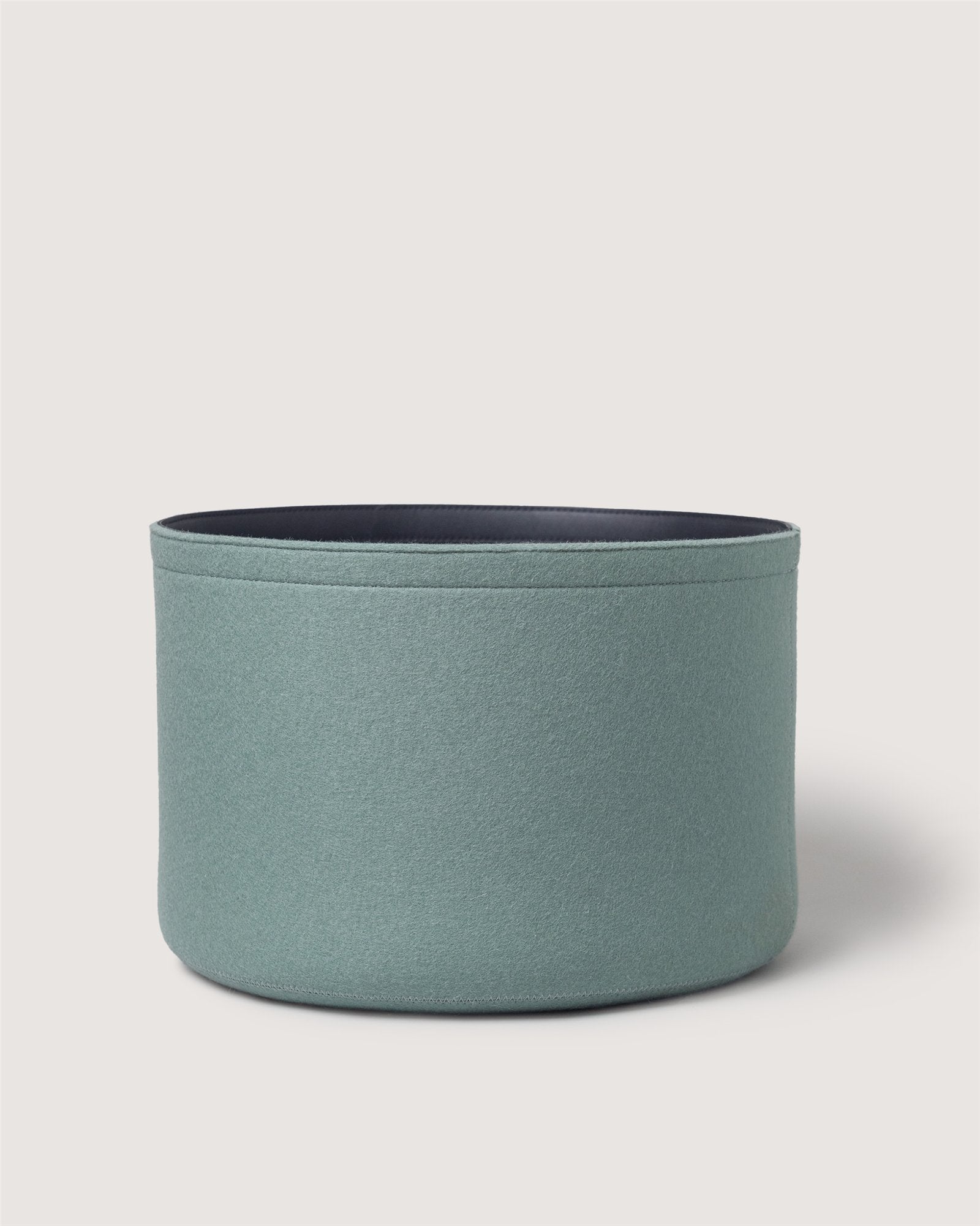 A light green, round Merino wool bin by Graf Lantz with a dark interior, perfect for sustainable organization, set against a plain white background.