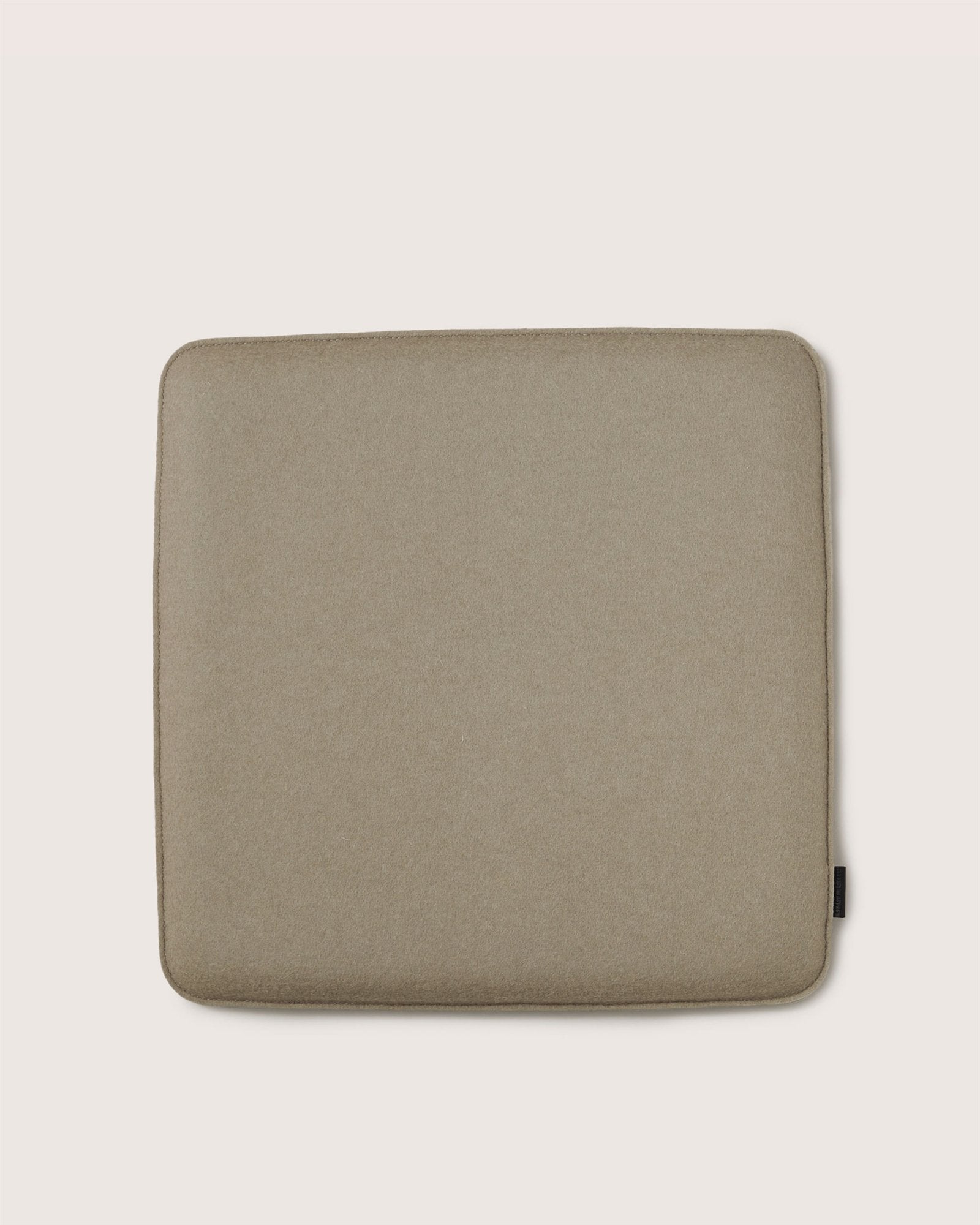 The Graf Lantz square beige Zabuton seat cushion features rounded corners and a subtle fabric texture, making it perfect for meditation. Displayed on a light background.