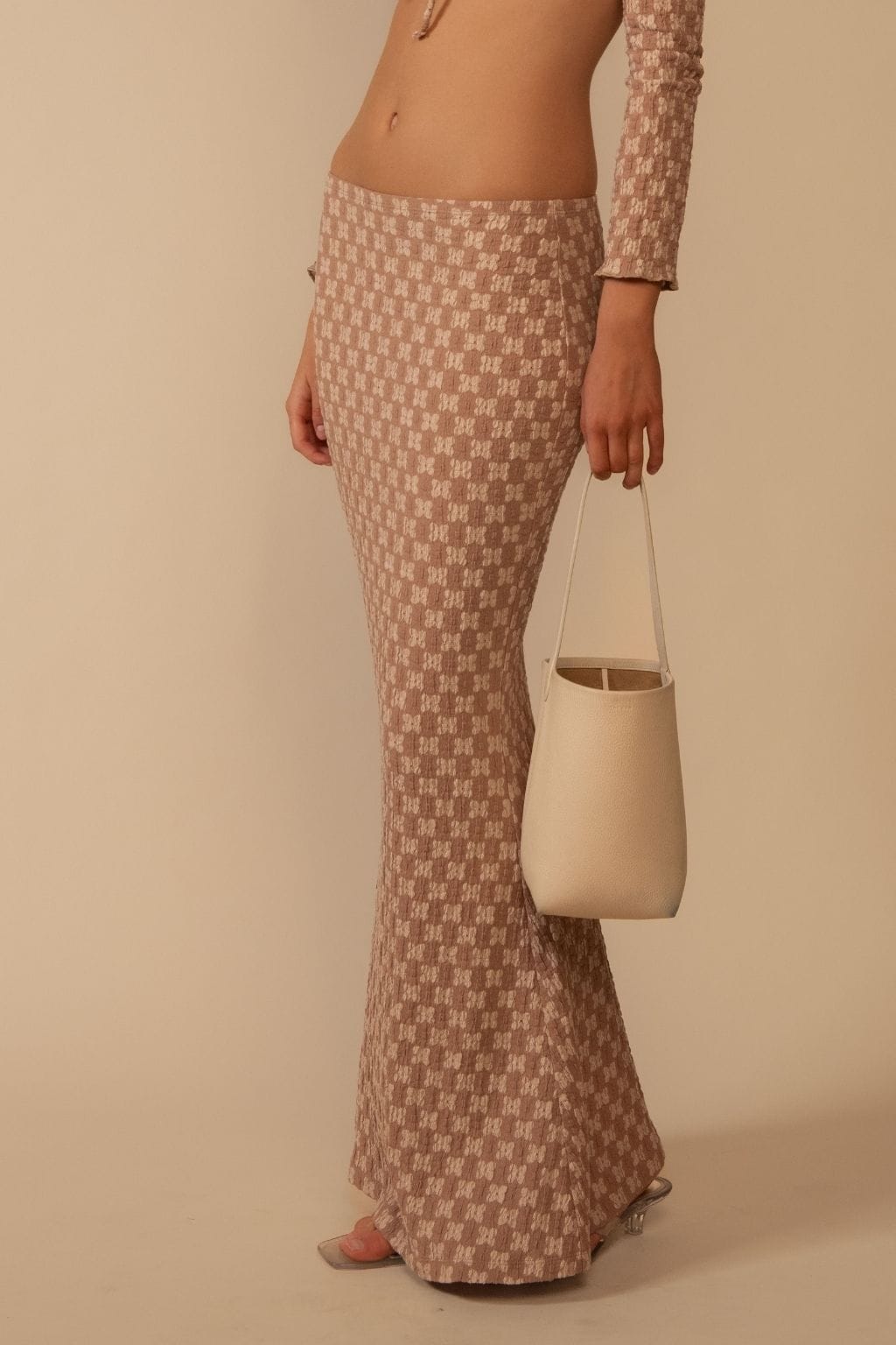 Mauve lace skirt with geometric pattern, floor-length fit, worn with matching long-sleeve top.