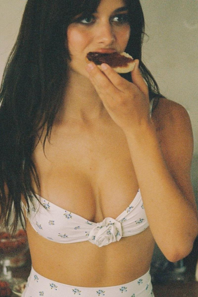 White bikini top with small floral print and front tie closure worn by model.