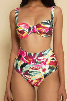 High-rise bikini bottom with multicolored floral print in pink, yellow, green, and black on cream background.
