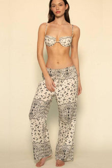Wide leg pant in cream with small floral and bandana print pattern throughout, worn with matching bandeau bikini top.