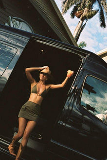 Khaki cargo skirt with multiple pockets worn by person standing in vehicle doorway.