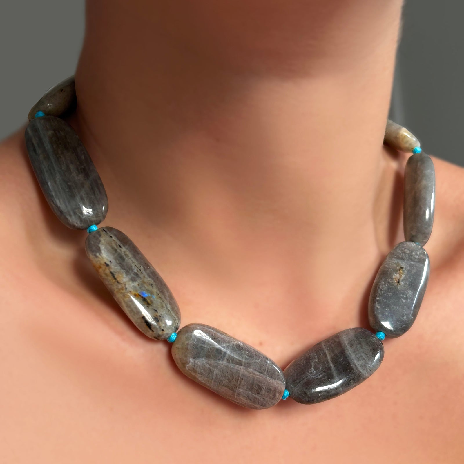 Labradorite Long Oval Necklace with blue thread on a model's neck.