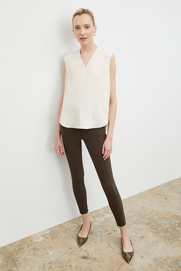 Front image of a woman standing wearing the curie pant in dark olive | Exclude