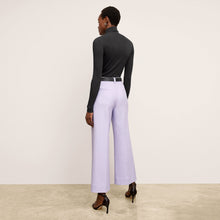 Back image of a woman standing wearing the axam top in black