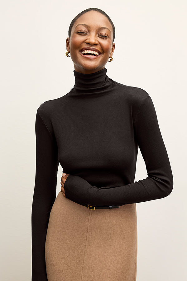 image of a woman standing wearing the axam top in black | Exclude | Grid