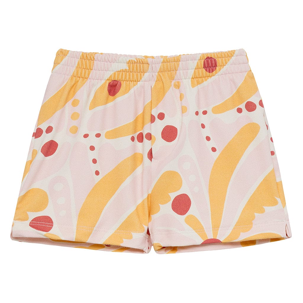 Pink and yellow swim trunks with red circular and curved palm leaf print design.