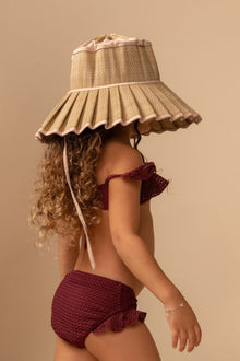 Maroon crochet bikini set with off-shoulder top and ruffled bottom displayed on model wearing tan bucket hat.
