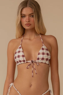 Maroon and cream plaid halter bikini top with tie closure, shown on model against neutral background.