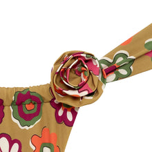 Dimensional rose pin with burgundy and cream petals attached to tan floral fabric strap with multicolored flower pattern.
