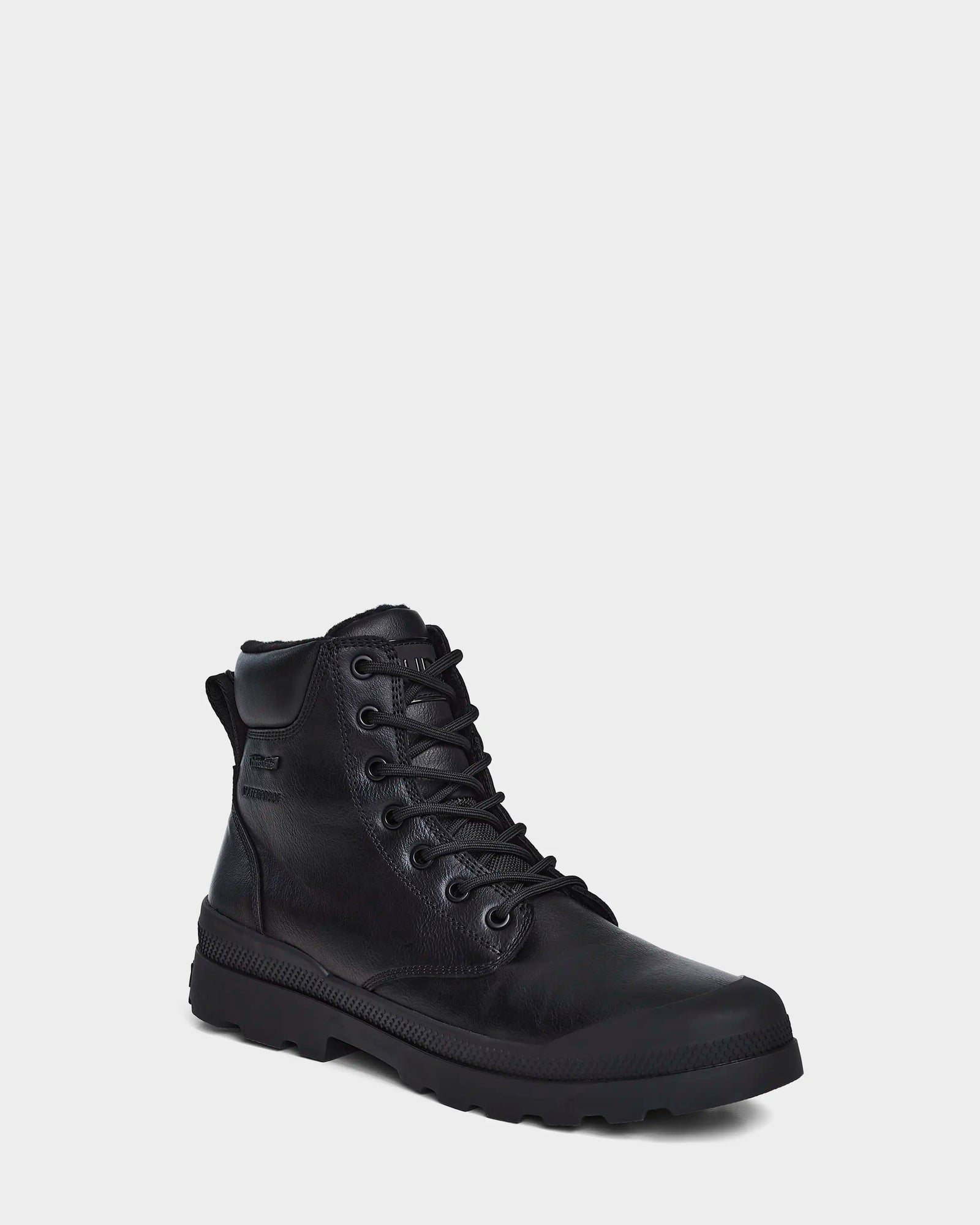 The Rudsak ARTUR - M223501 Black is a men's ankle boot with weather-treated leather, rugged rubber sole, metal eyelets, and reinforced stitching, shown at a slight angle on a plain light gray background.