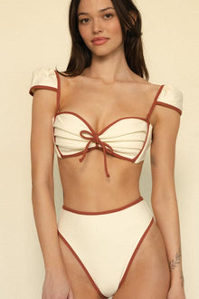 Oat and terracotta bikini top with bow tie-front detail and puffed off-shoulder straps.
