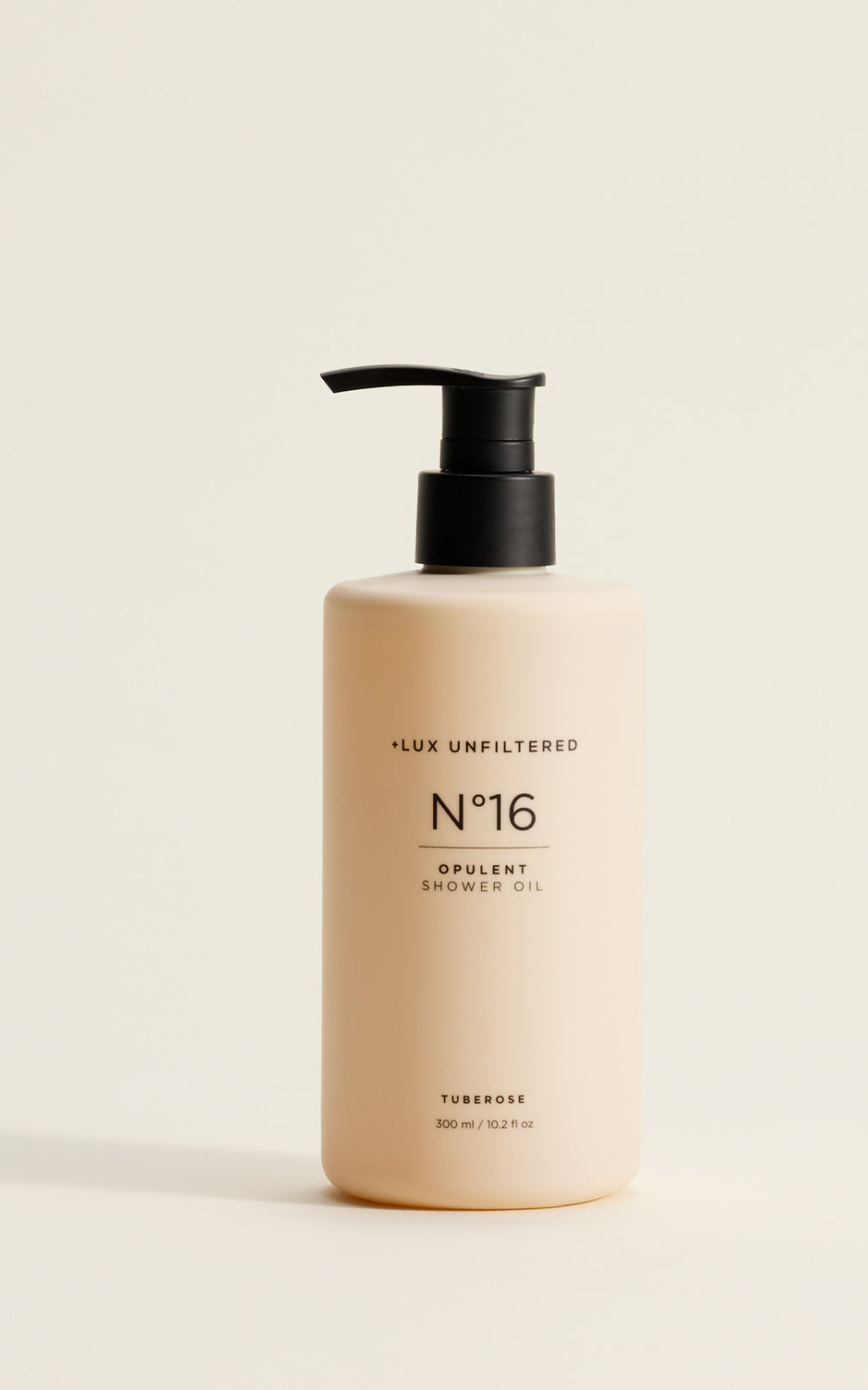 Front view of LUX Unfiltered N°16 Opulent Shower Oil pump bottle showing beige bottle, black pump, and 'Tuberose' scent label on a neutral background