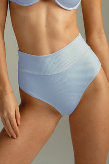 Light blue ribbed high-rise bikini bottom with wide waistband on model.