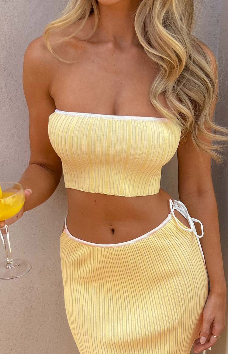 Close-up of the yellow ribbed knit tube top with white contrast binding at the strapless neckline