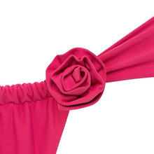 Bright pink fabric rose pin attached to matching pink elastic band and draped fabric.
