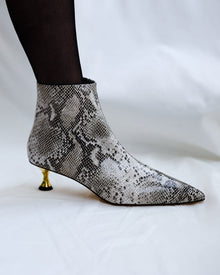 A snake-skinned leather boot with gold kitten heel
