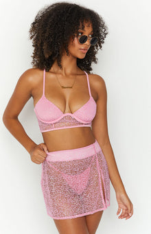 Close-up of the pink sparkle mini skirt showing the high side slit and textured fabric