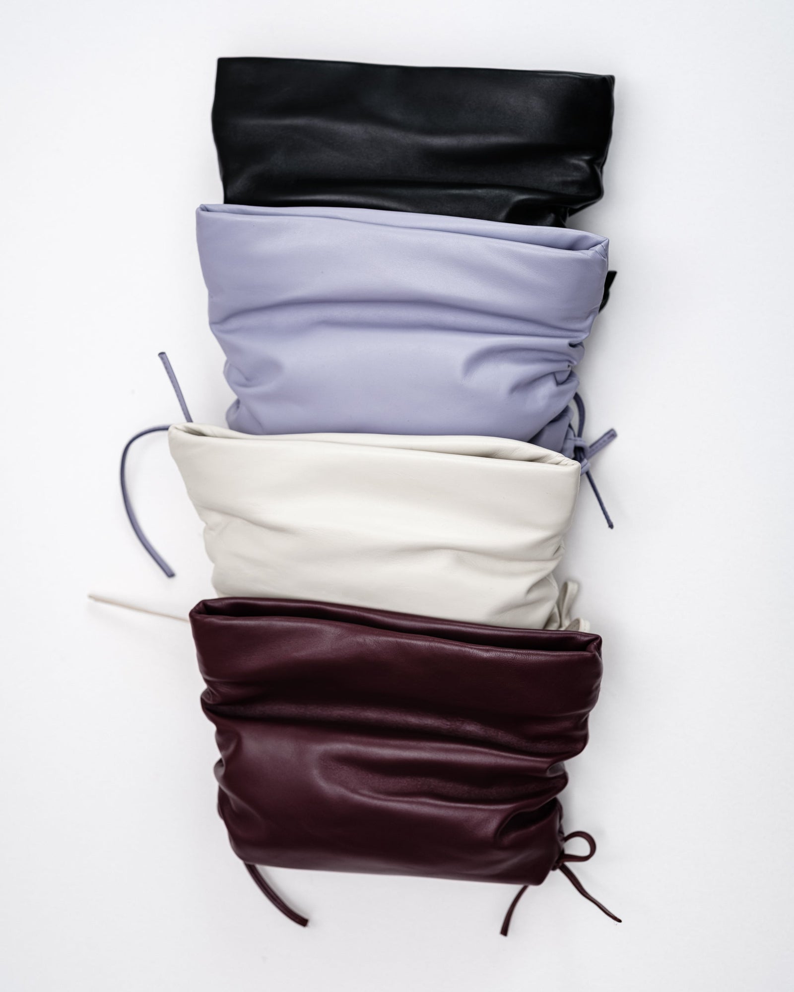 Four leather clutches on a white background