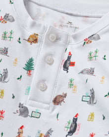 Kid's Pima Snug Fit Pajama Set in Merry Meow features a long-sleeve button-up top and matching pants with winter and holiday-themed prints of cats, trees, presents, and snowmen on a white background.